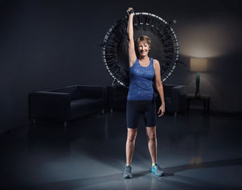 Active aging female standing tall and holding the JumpSport up in the air.