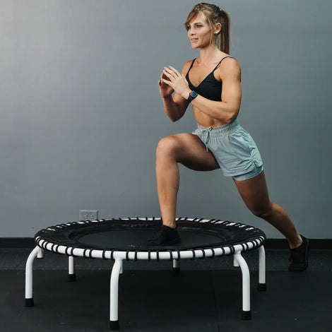 Girl doing lunges on a white JumpSport 44 inch PRO solid frame with arched legs, model 550 PRO Club Edition