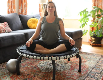 Woman sitting and meditating on her Wellness Trampoline