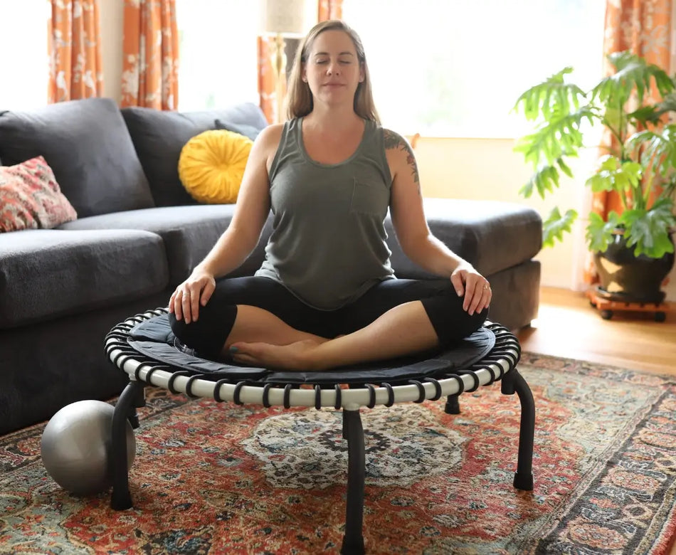 Woman sitting and meditating on her Wellness Trampoline
